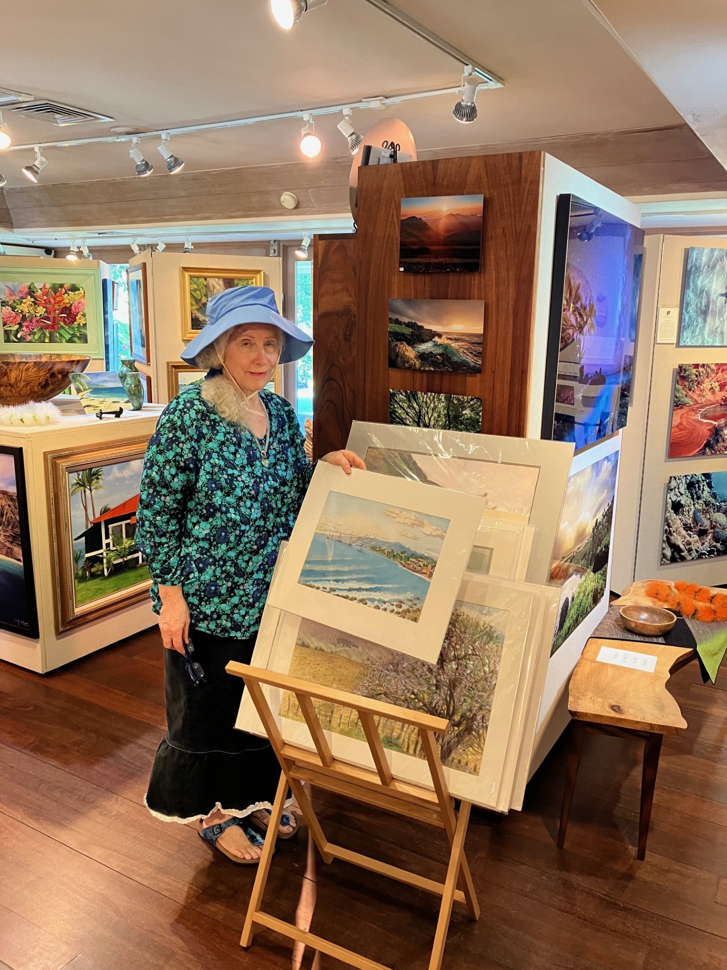 Barbara Steinberg displaying her framed watercolor giclée prints at a Maui art gallery